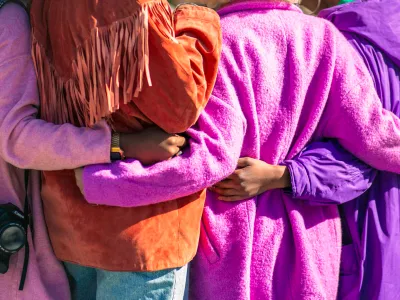 Women holding each other in the back