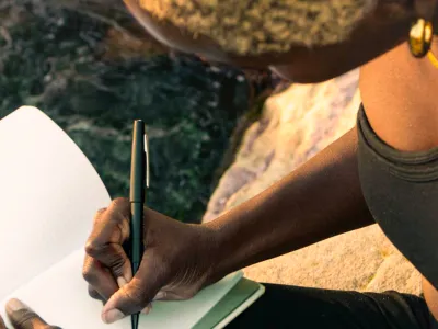 A person writes on a journal