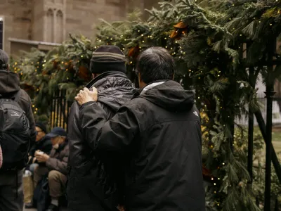 People wait in line for Christmas groceries distribution in front of Trinity Church.