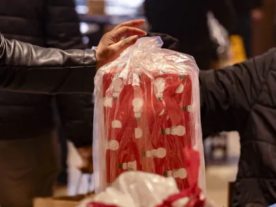 A lady picks up a wrapped gift in line.