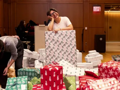 A person is making a pose on top of a wrapped gift.