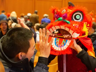 A child wears a lion mask at Trinity's Lunar New Year celebration.
