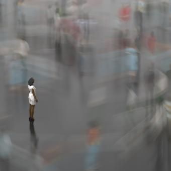 A person stands still amid a whirling, blurry crowd