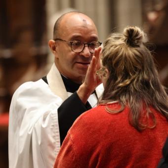 Father Phil Jackson imposes ashes on a parishioner on Ash Wednesday in Trinity Church