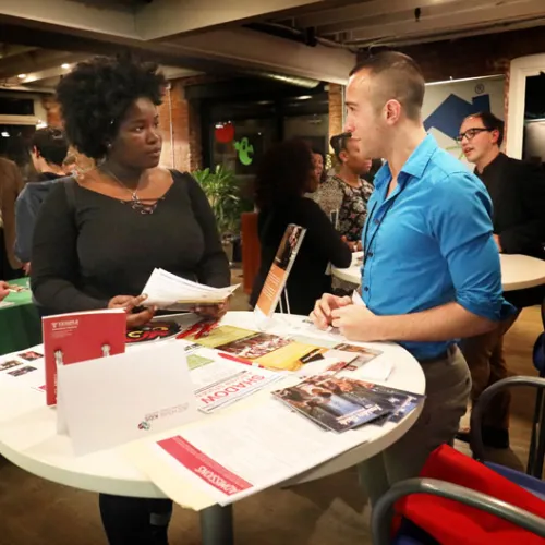 Two people stand at a table