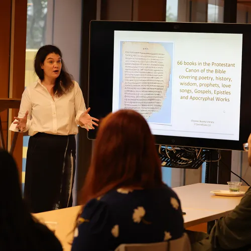 Summerlee Staten stands before a room of listening students at the Foundations course