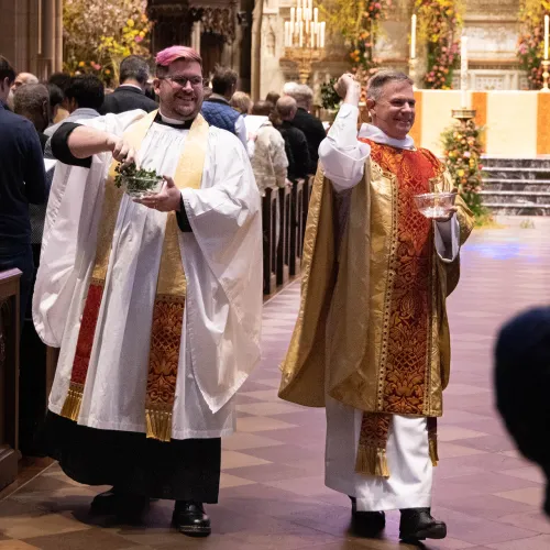 Fr. Matt Welsch and Fr. Michael Bird asperge the congregation (sprinkle with holy water) to remind us of our baptism and to share the joy of all who have been baptized at Easter.