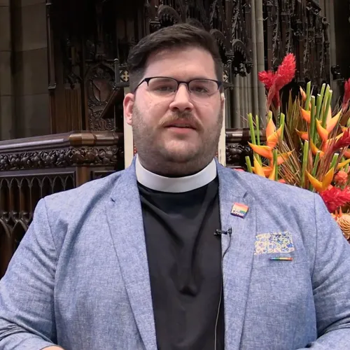 Father Matt Welsch stands inside Trinity Church