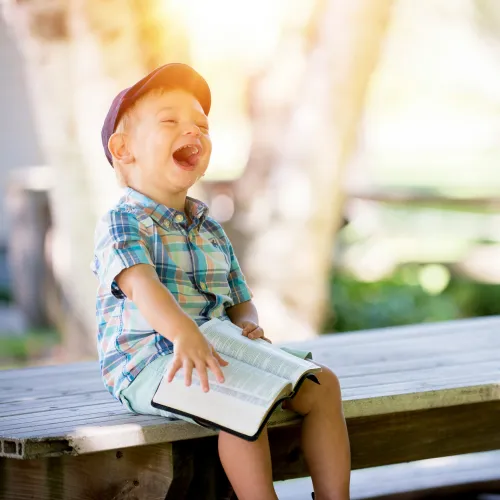 A laughing kid with a book