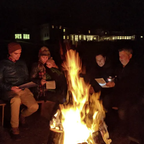 People gather at the bonfire.